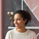 Portrait of a smiling woman in her 30s, representing a happy and trusted customer.